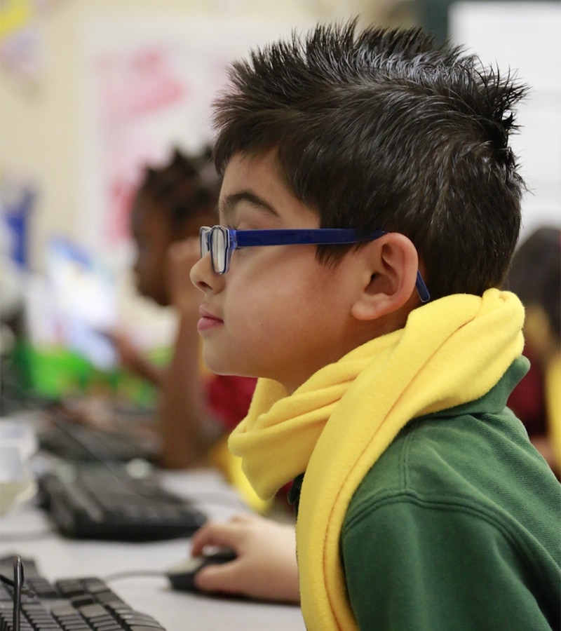 boy in yellow scarf using a computer