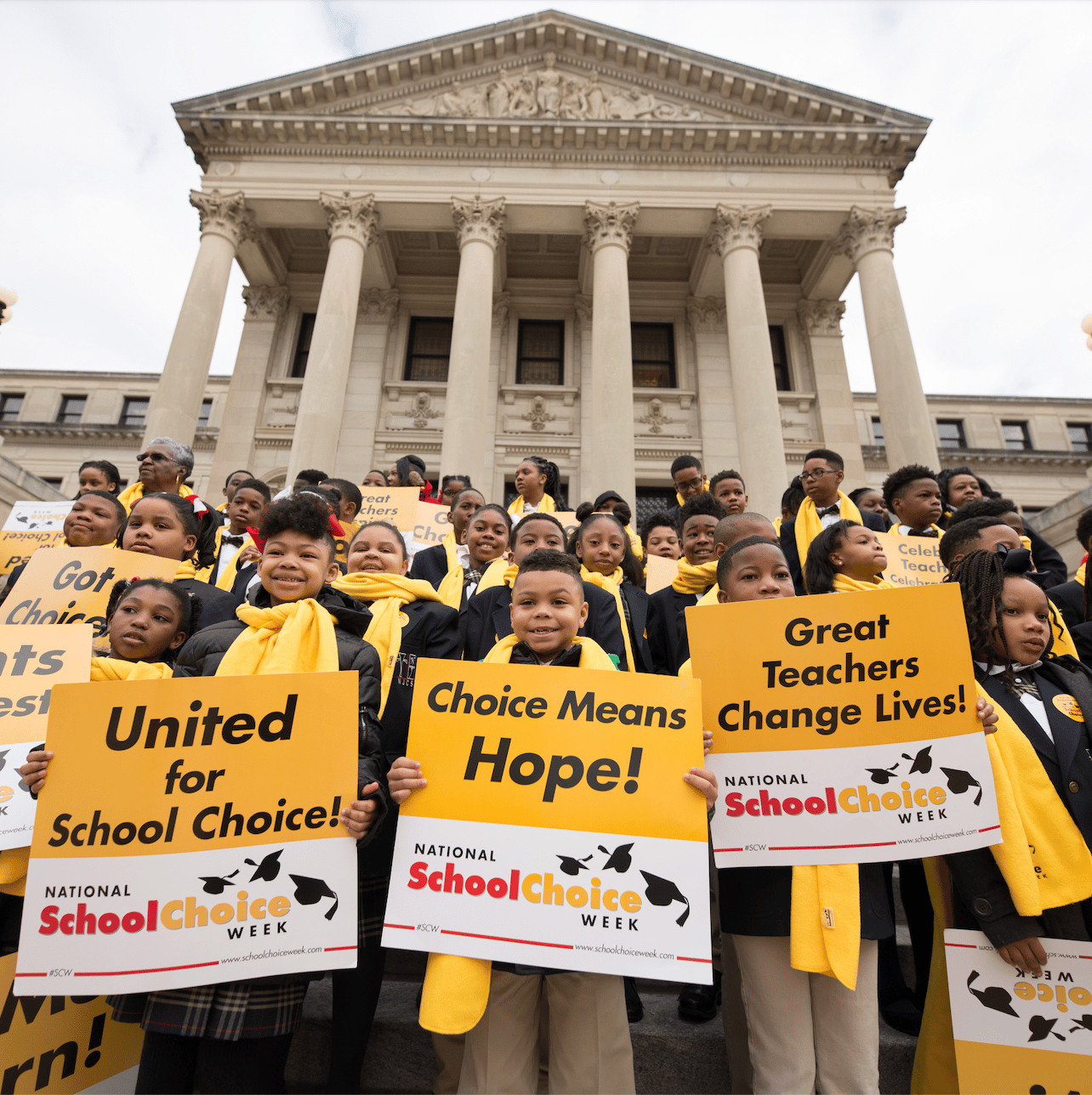 students in yellow scarves on state capitol building steps